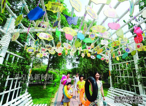 平水橋公園綠化廊架上懸掛的社會(huì)主義核心價(jià)值觀小吊牌吸引了過(guò)往游客的目光